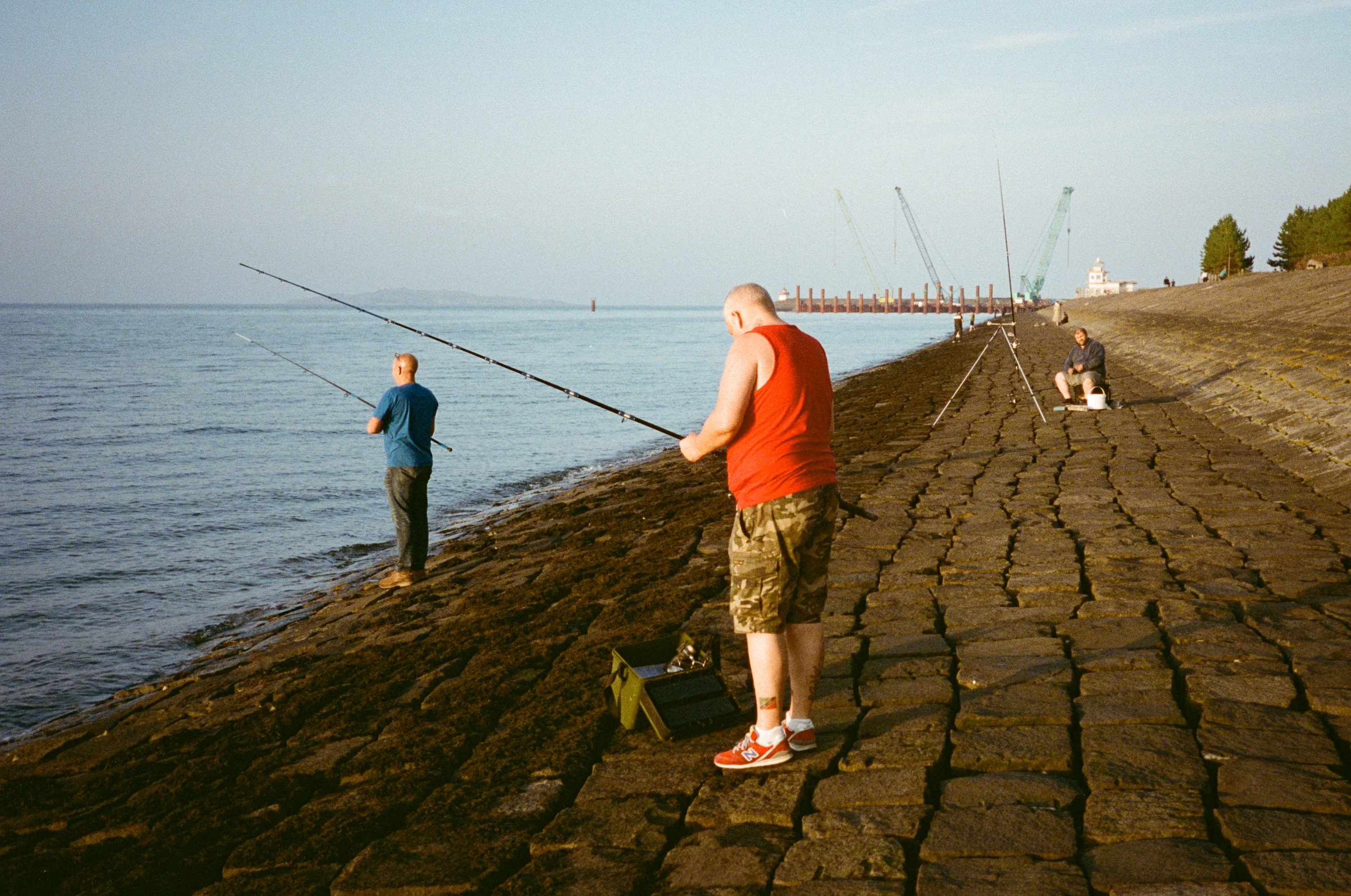 Two anglers casting from a cobbled slipway into the Forth