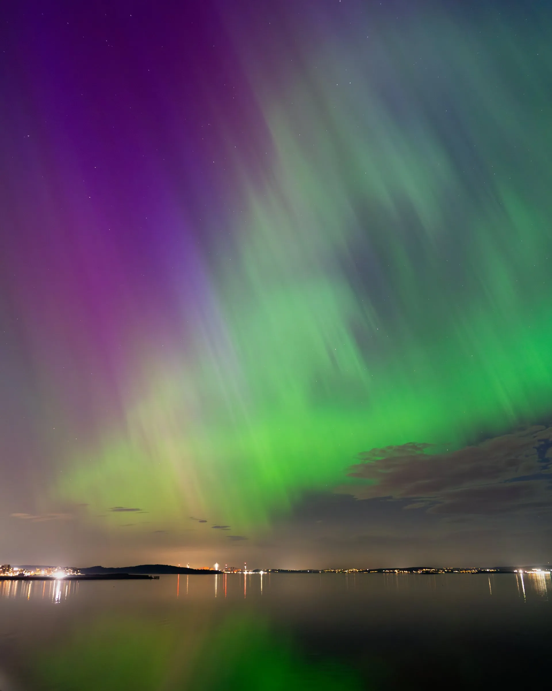 Green and purple northern lights over the Firth of Forth