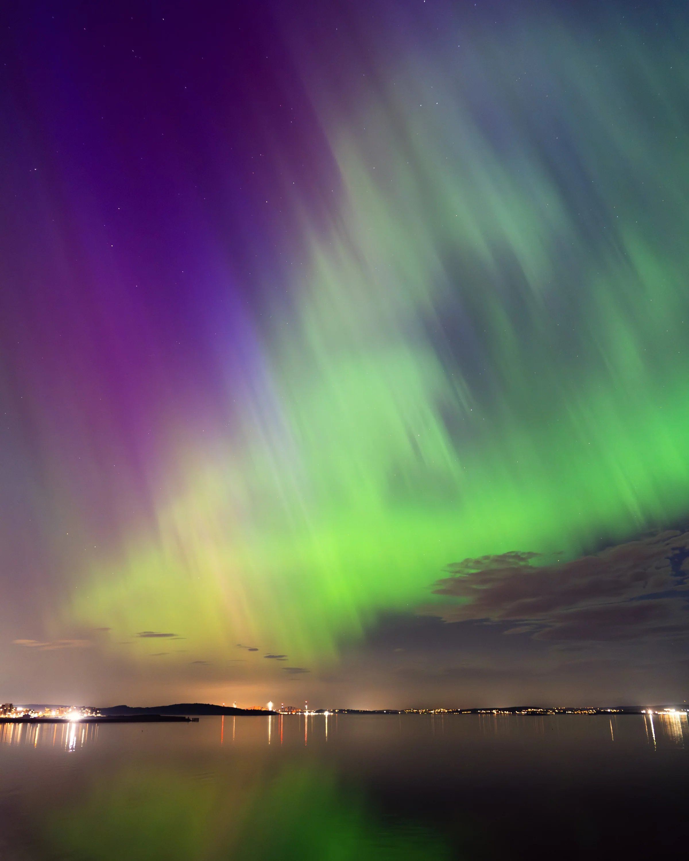 Green and purple northern lights over the Firth of Forth