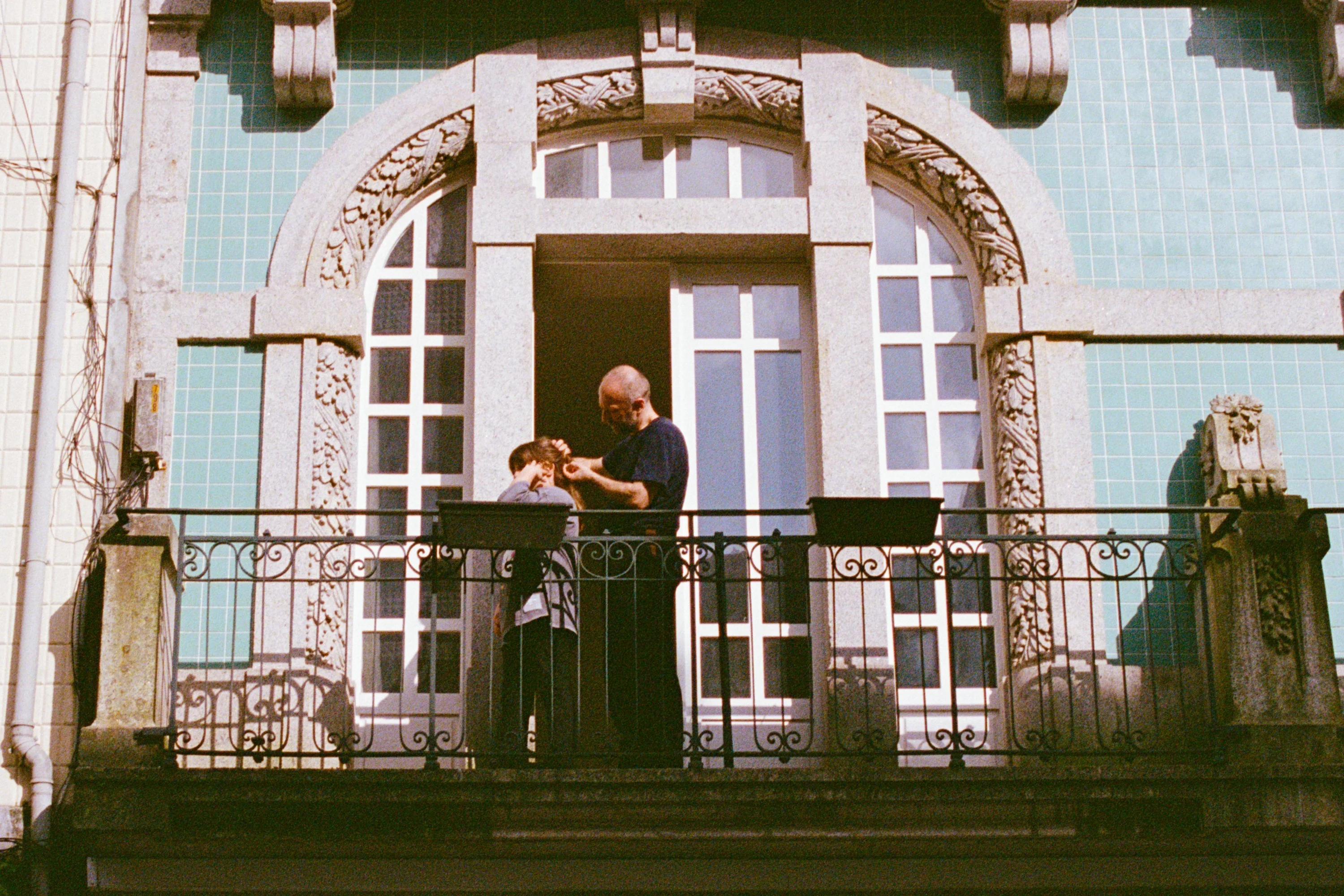 A musician playing on a tiled balcony