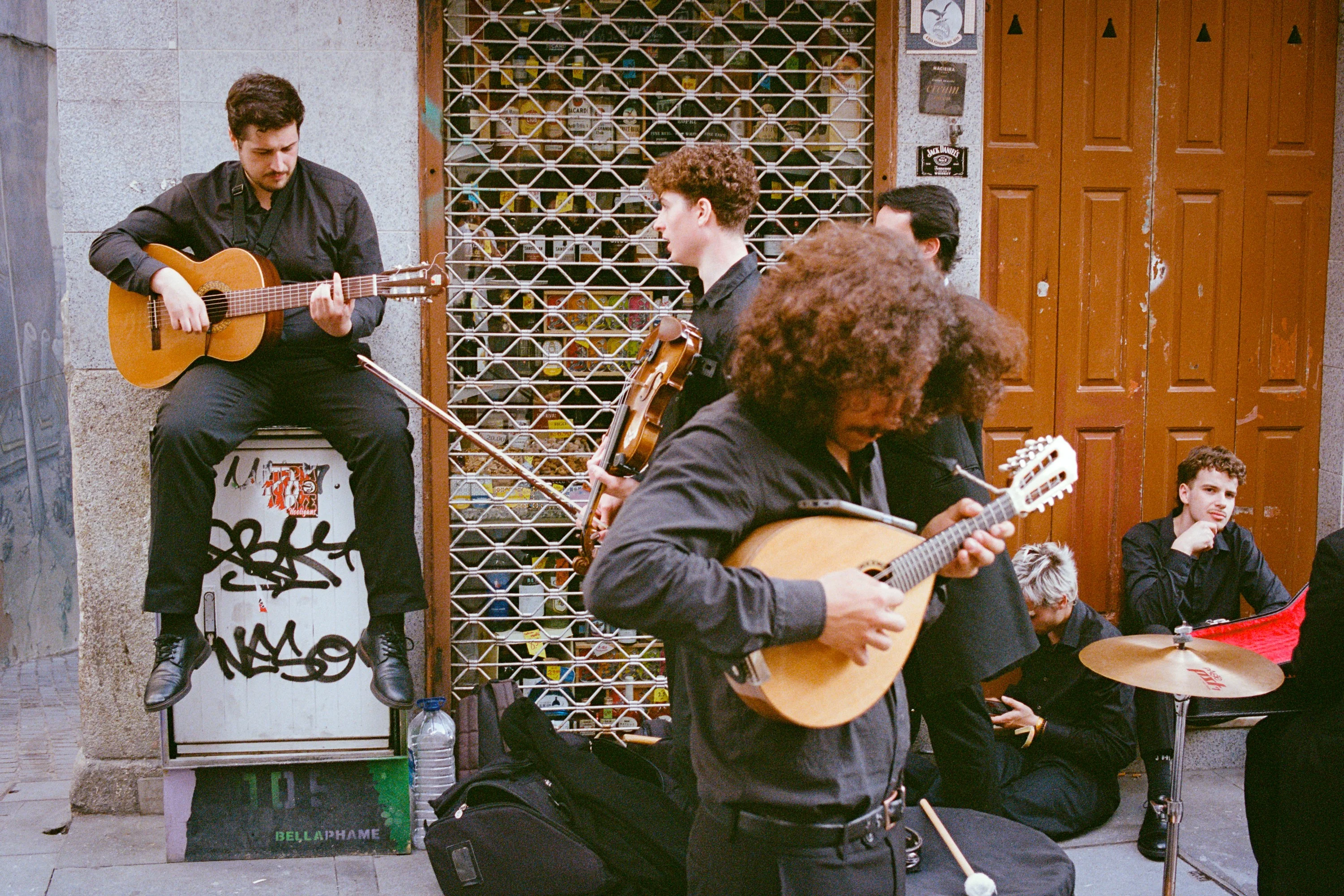 Buskers playing guitar, violin and mandolin in a doorway