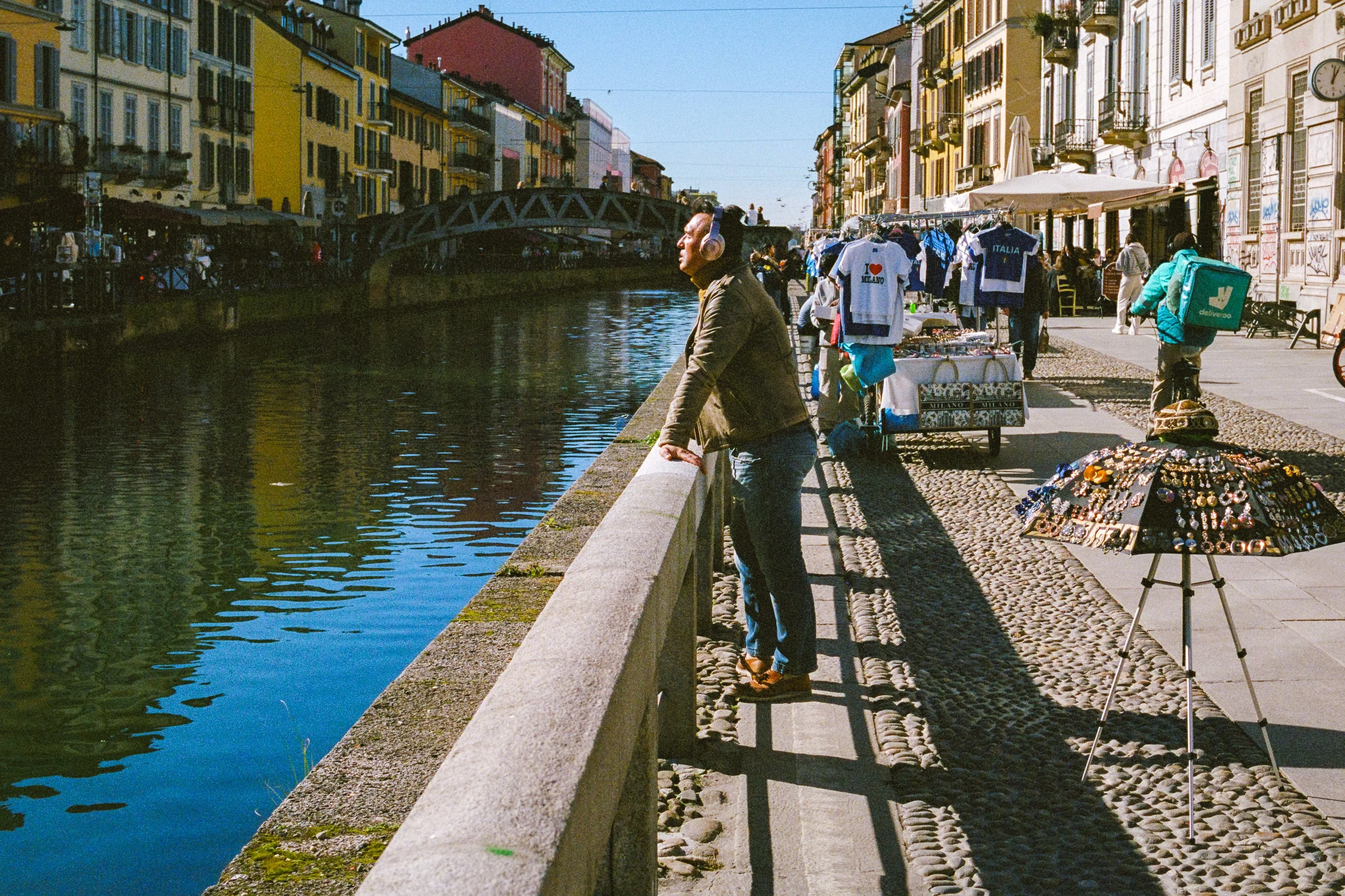 A man leaning on a canal wall on the Navigli