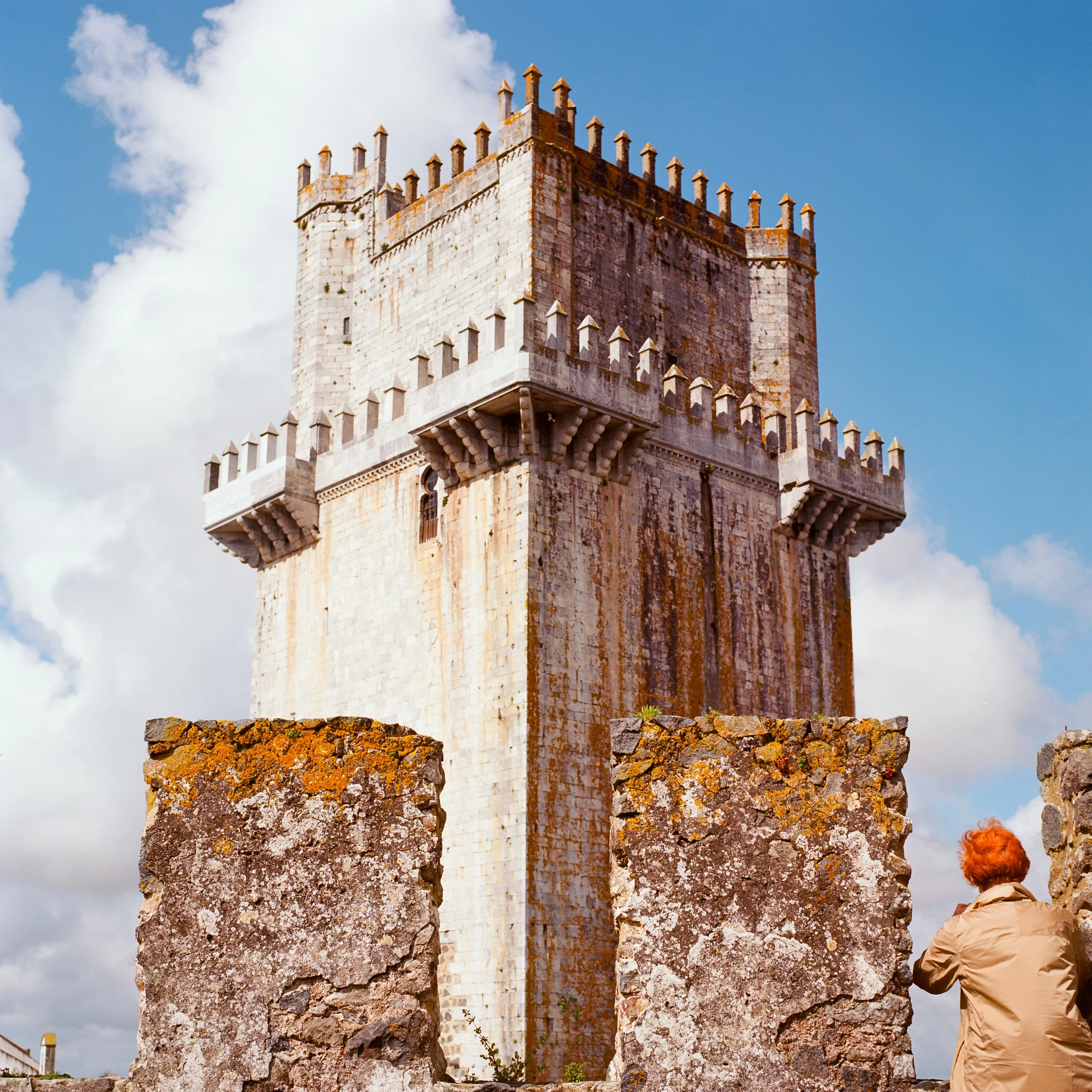 A crenellated stone tower against clouds