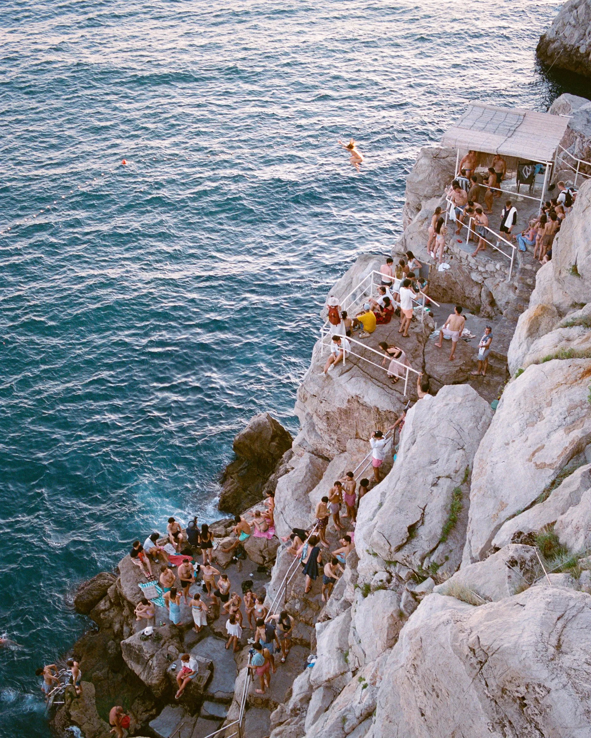 Swimmers on the rocks below Dubrovnik's walls