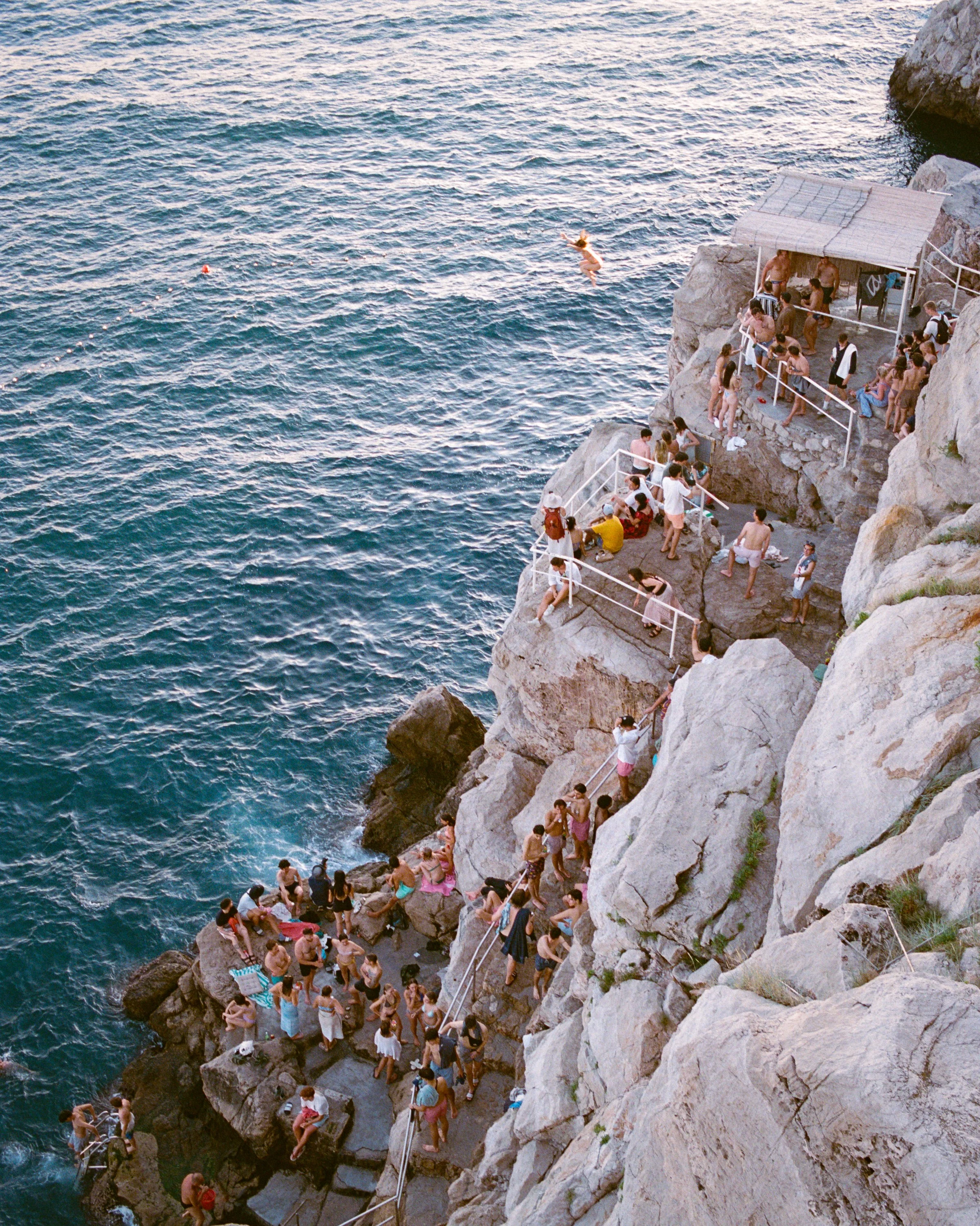 Swimmers on the rocks below Dubrovnik's walls
