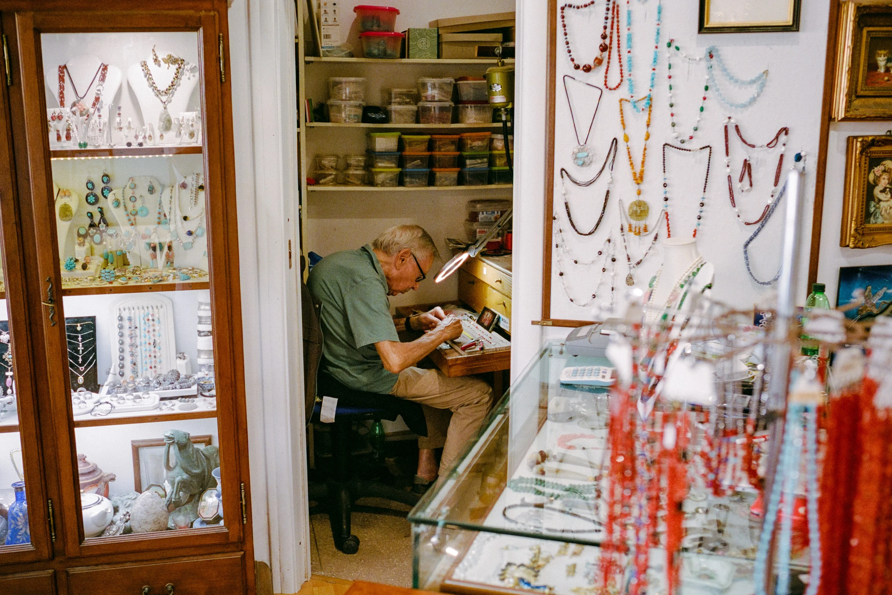 A jeweller at work in a shop of coral necklaces