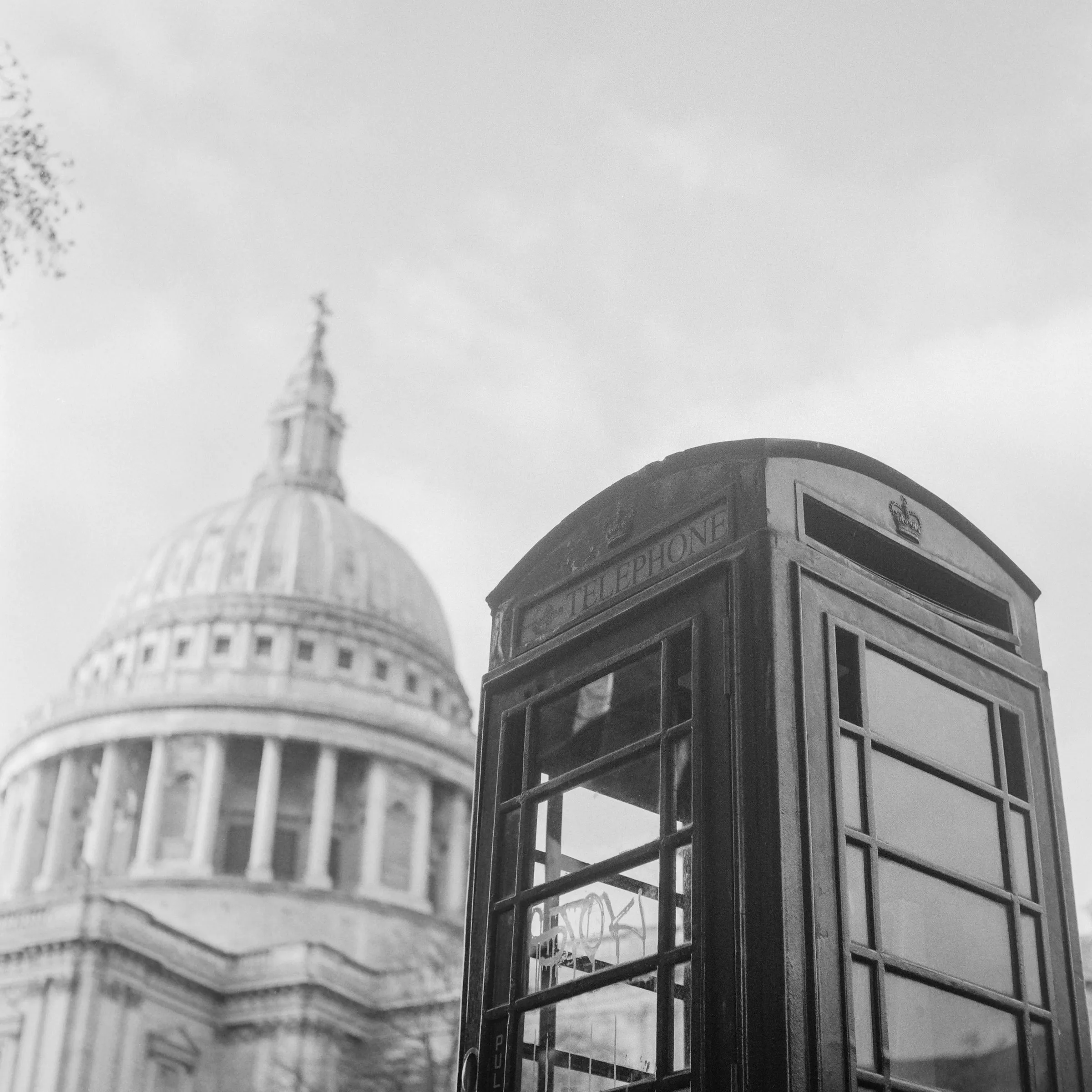 Black and white photo of St Paul's dome beside a phone box