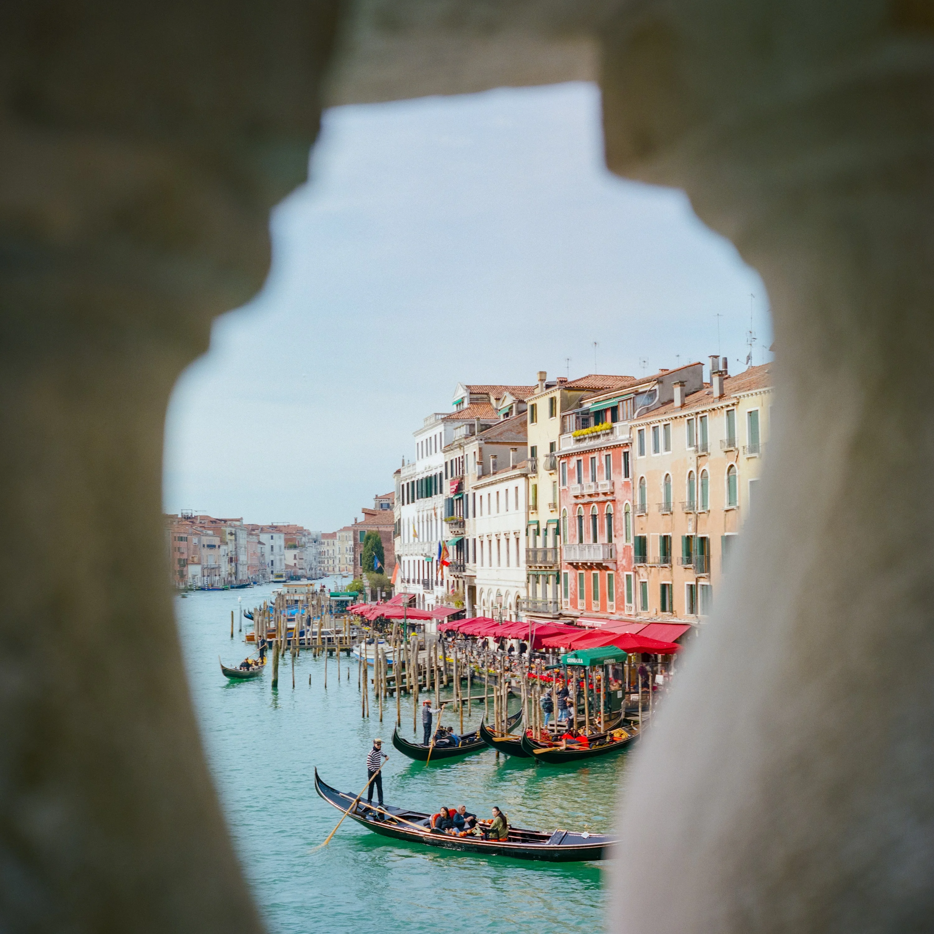 The Grand Canal and gondolas seen through a stone opening