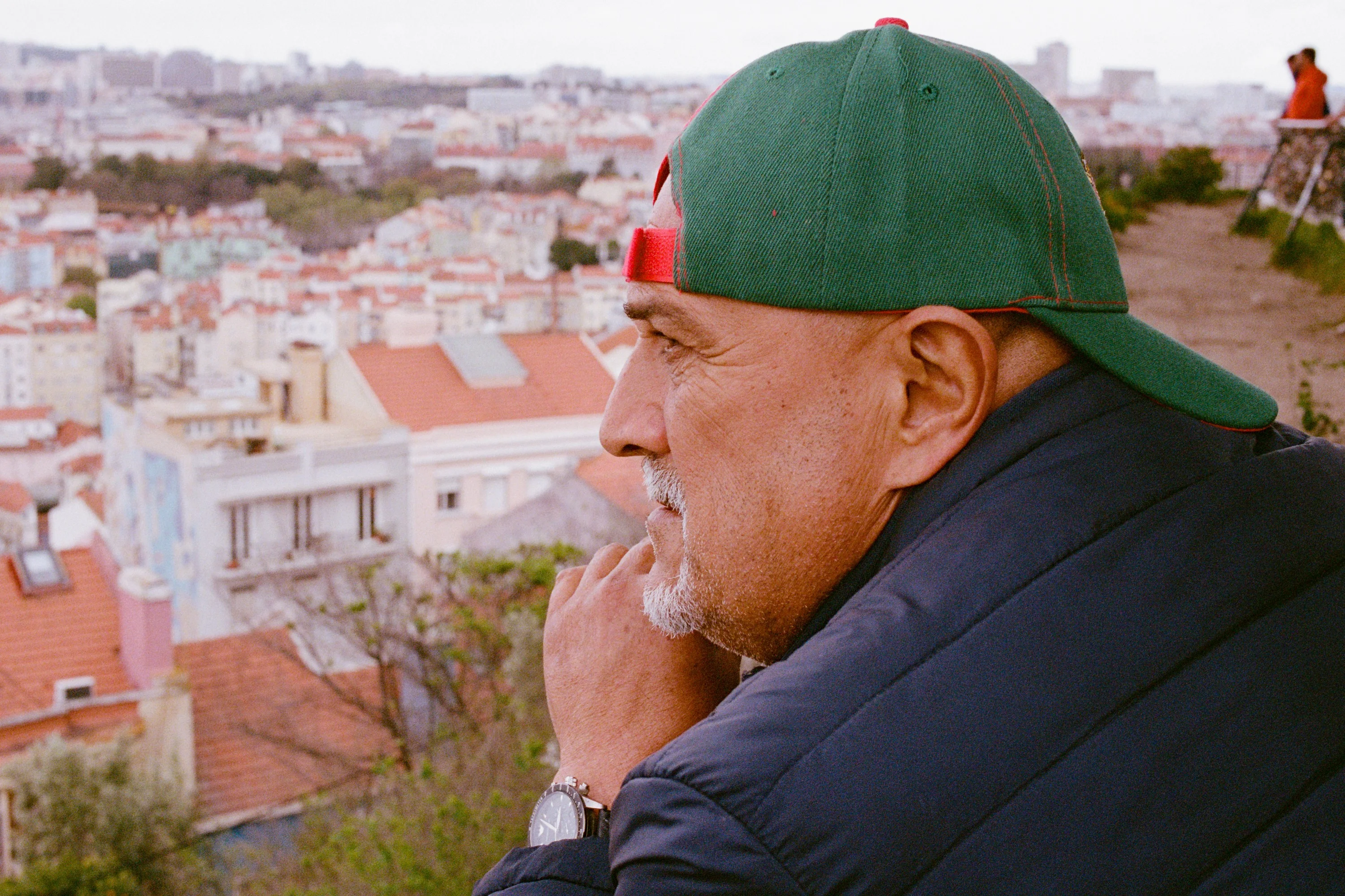 A man in a green cap looking over the rooftops