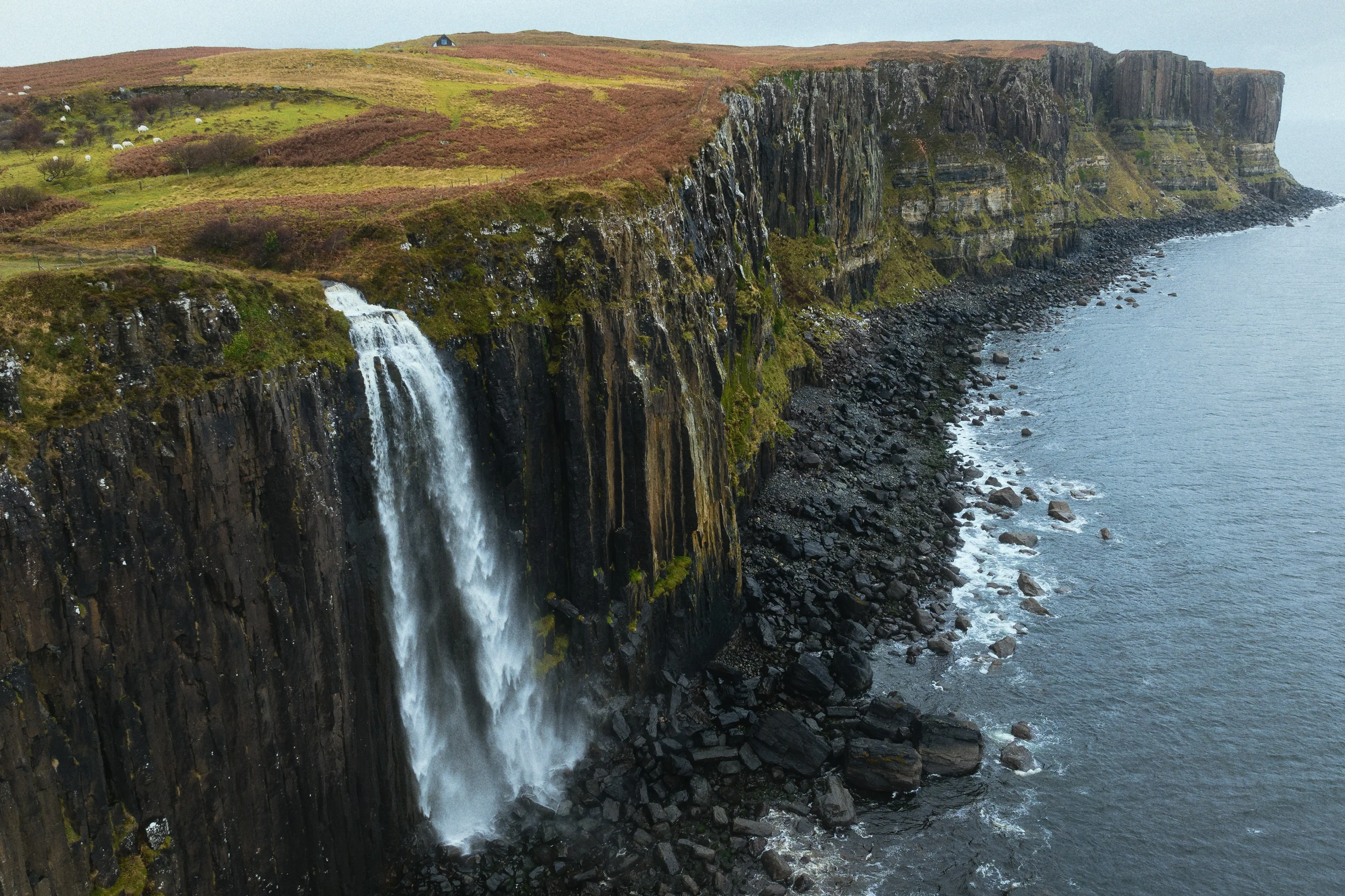 A waterfall dropping off Kilt Rock's basalt cliffs into the sea