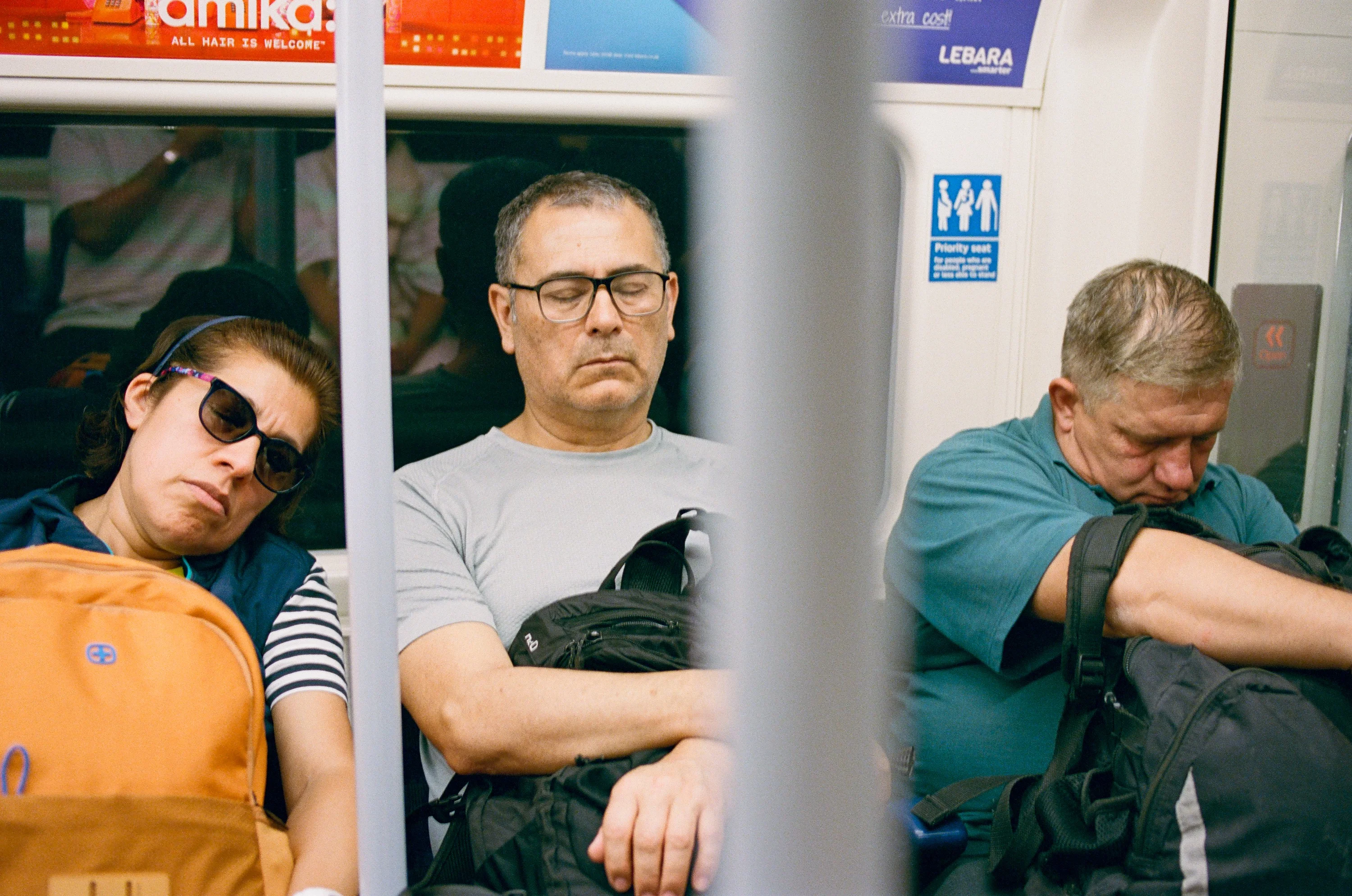 Passengers asleep on a London Underground train
