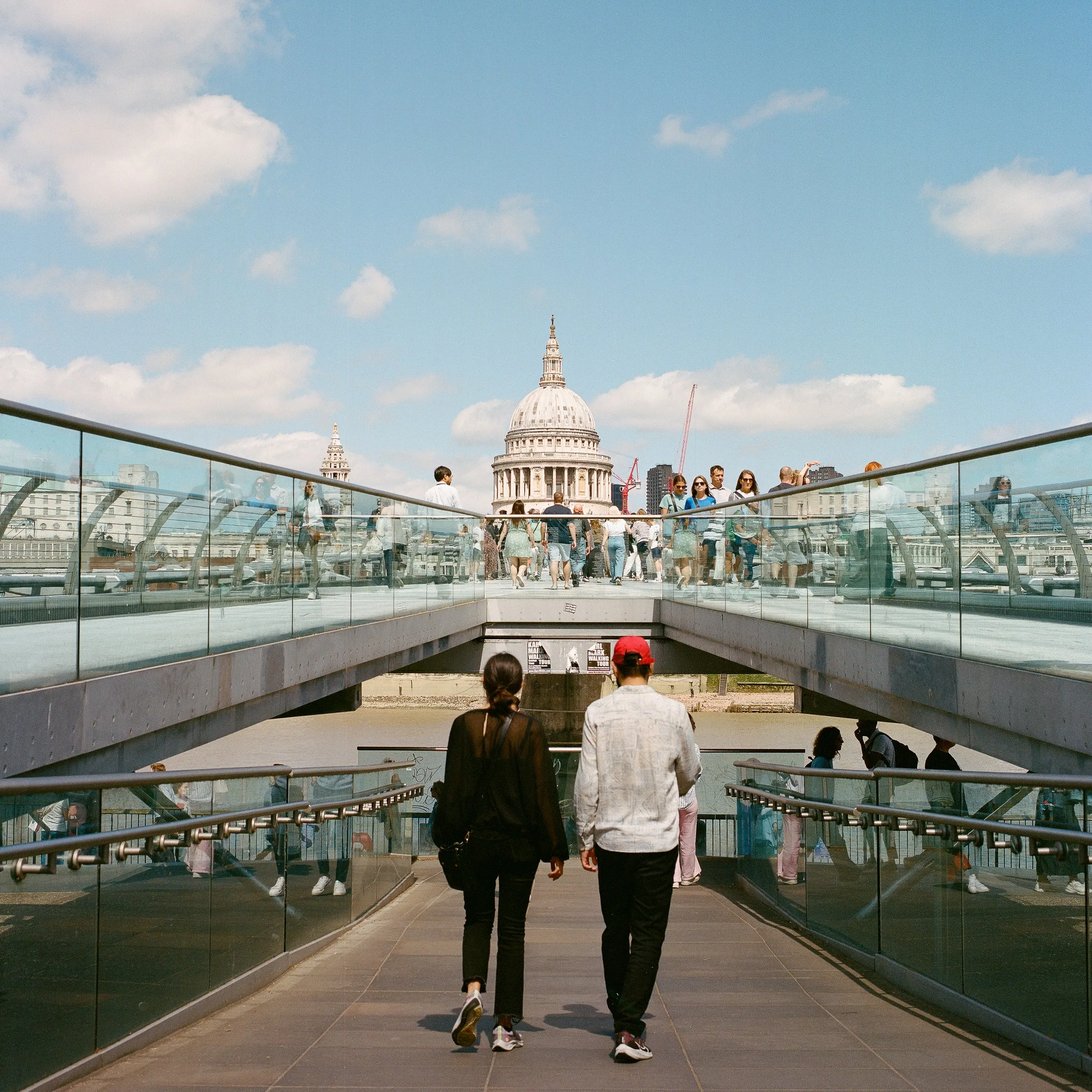 A couple walking across the Millennium Bridge towards St Paul's