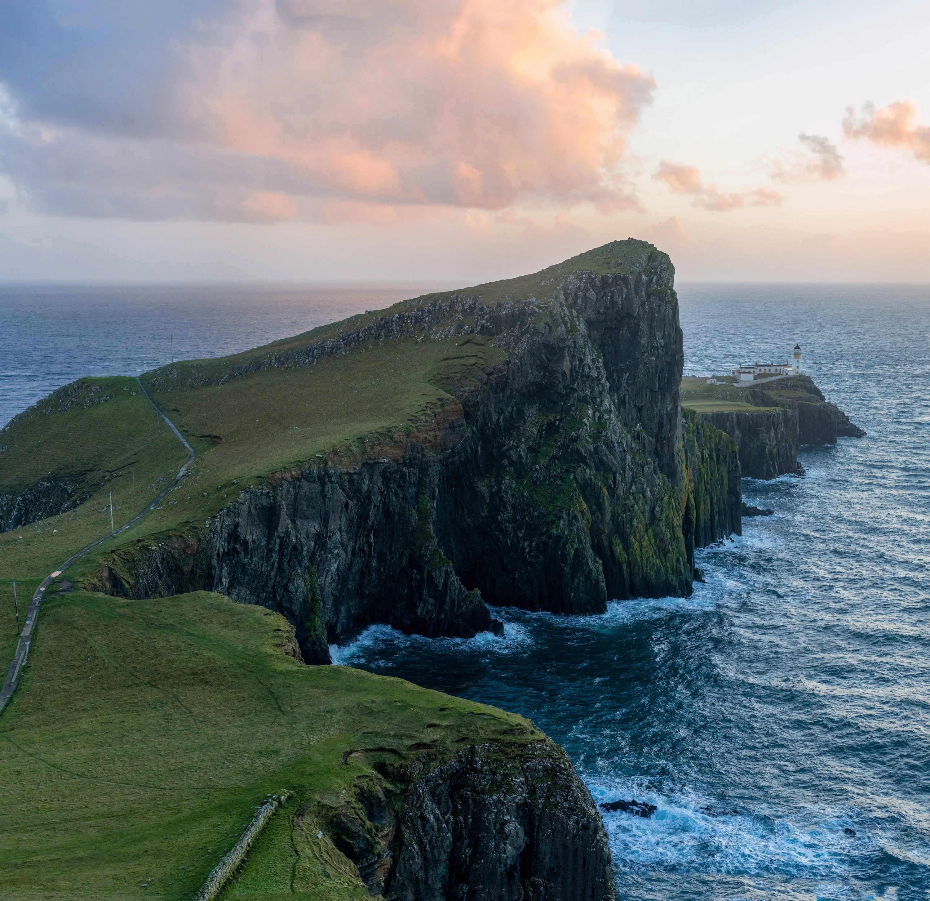 Neist Point's cliffs and lighthouse under evening cloud
