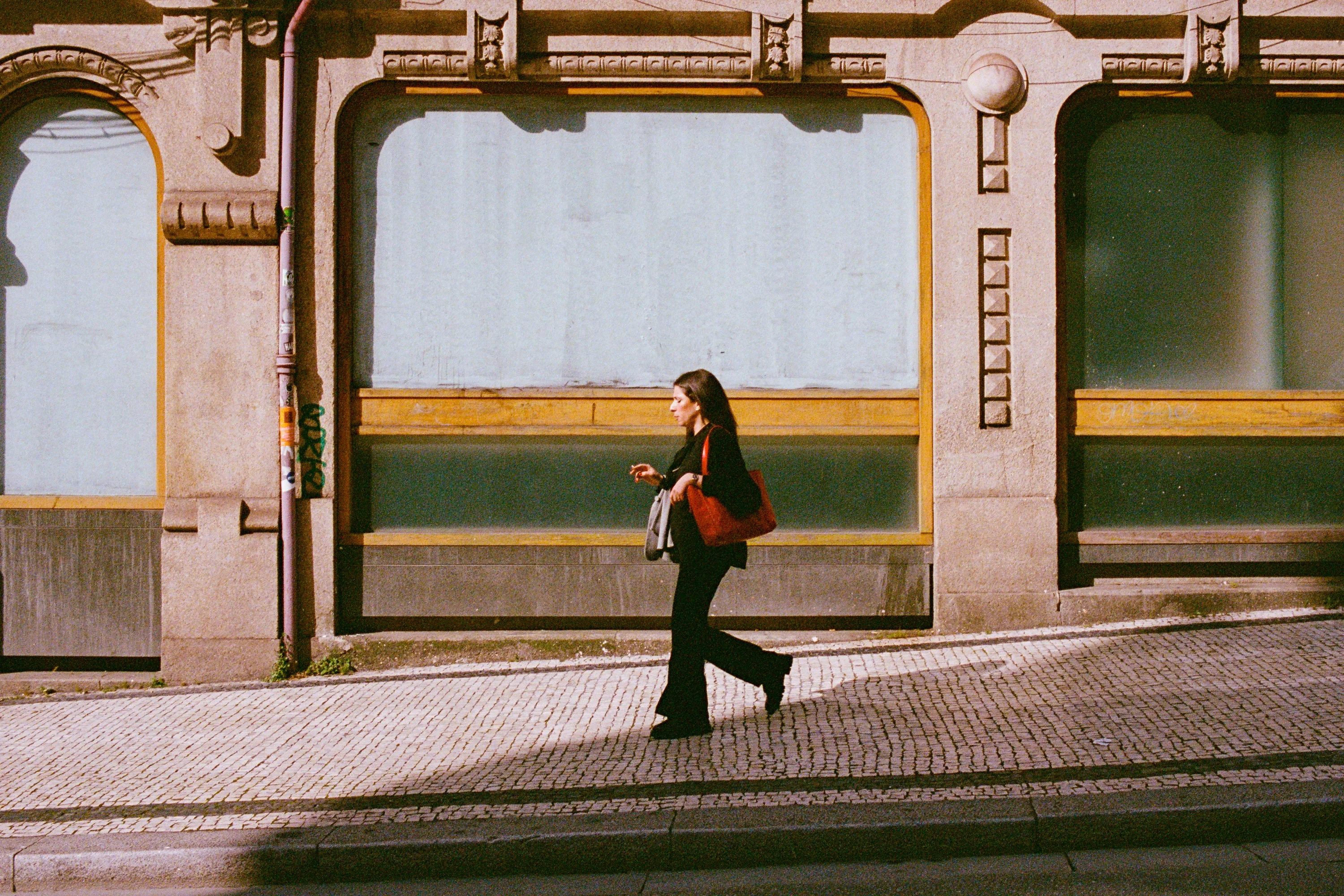 A woman walking past an old shopfront