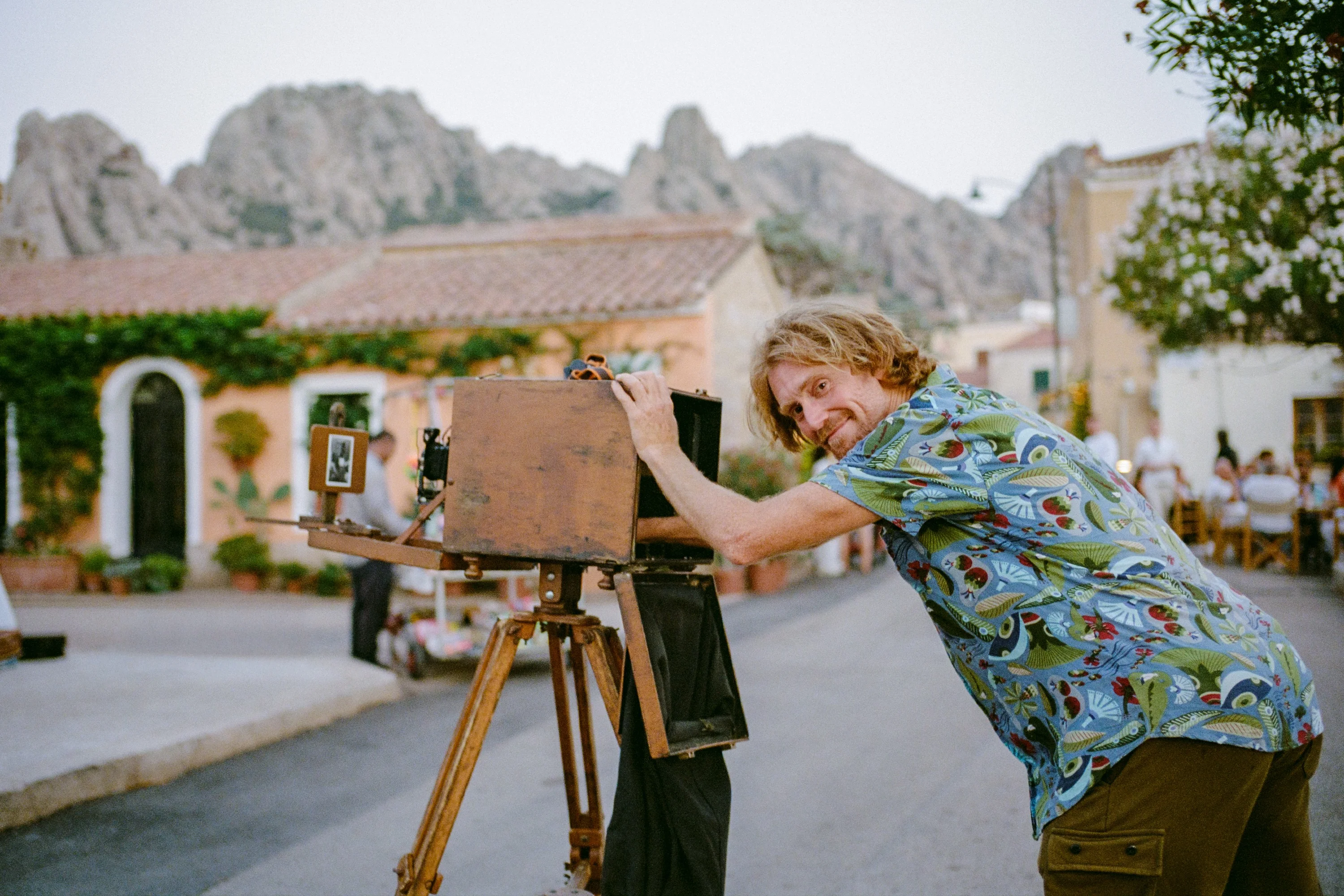A photographer leaning on a large-format camera