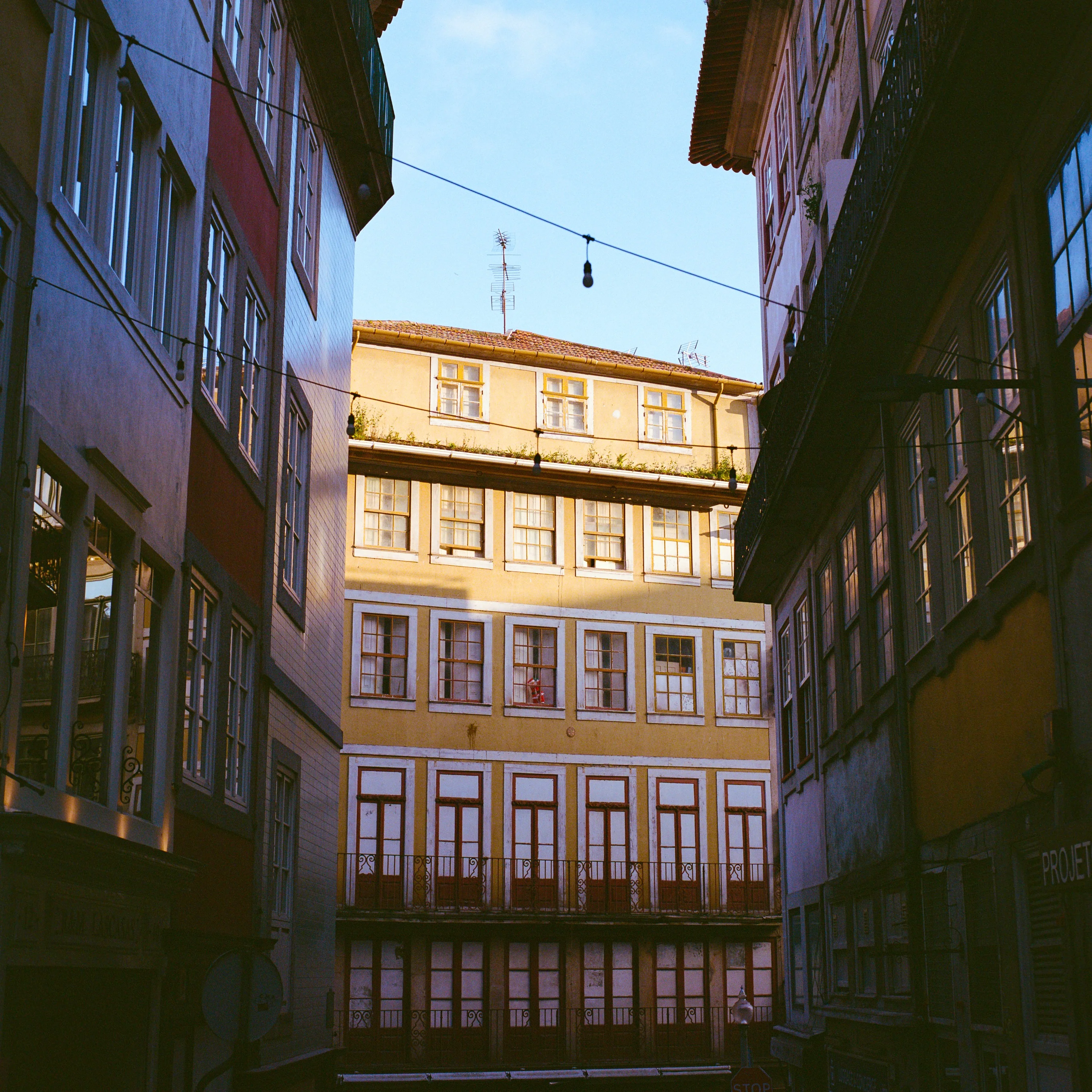 A yellow building at the end of a narrow alley