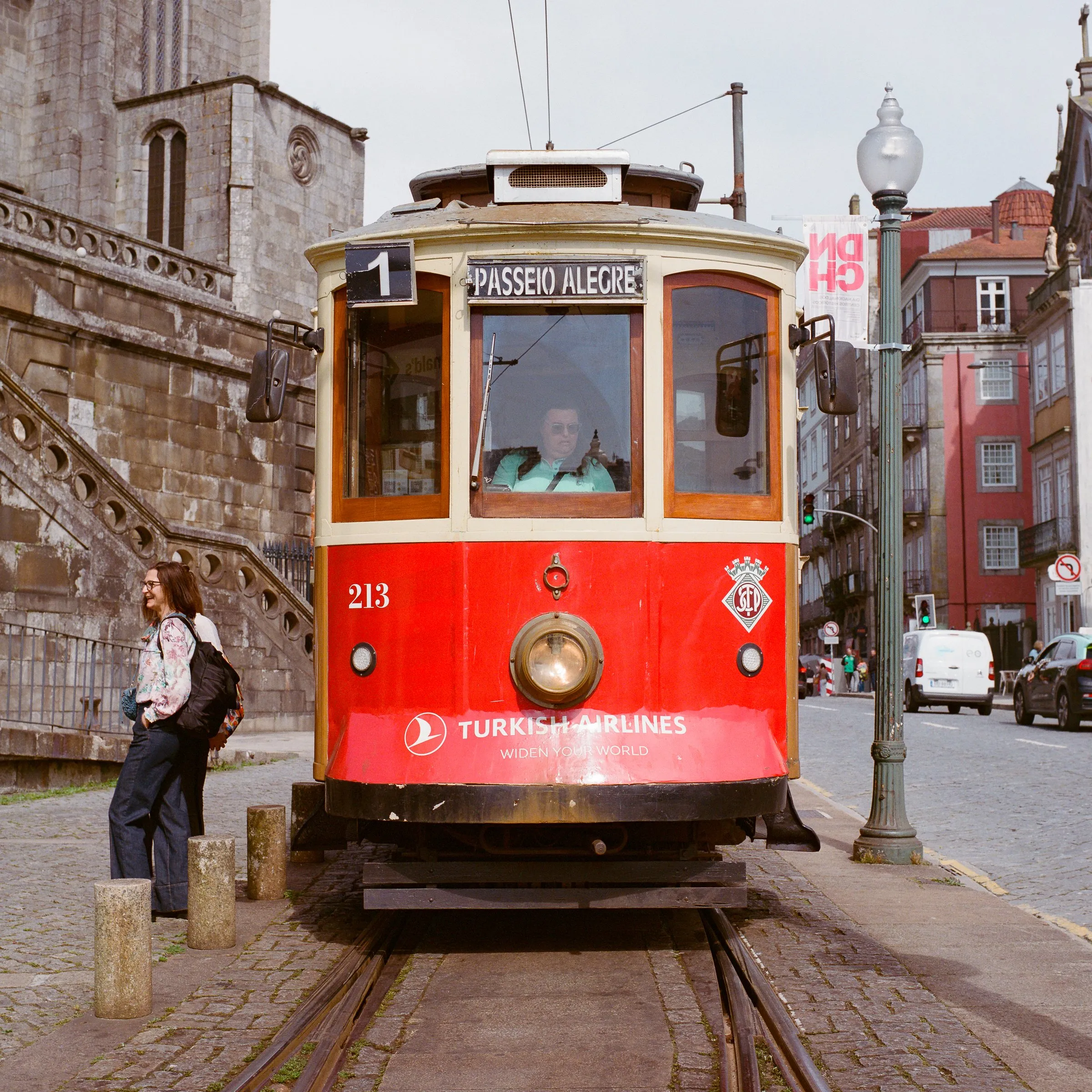 A red heritage tram on the line in Porto