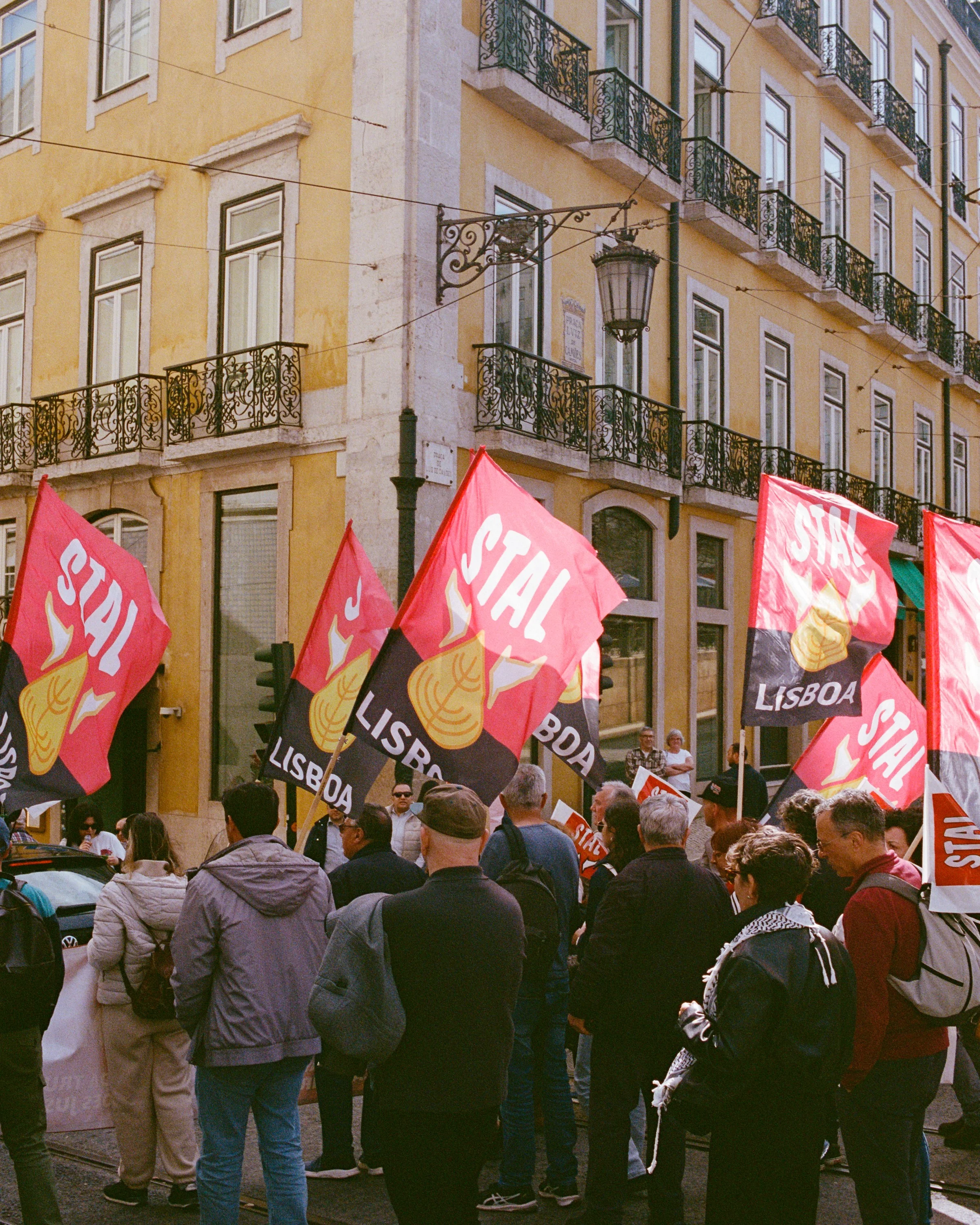 Protesters with red flags in a yellow street