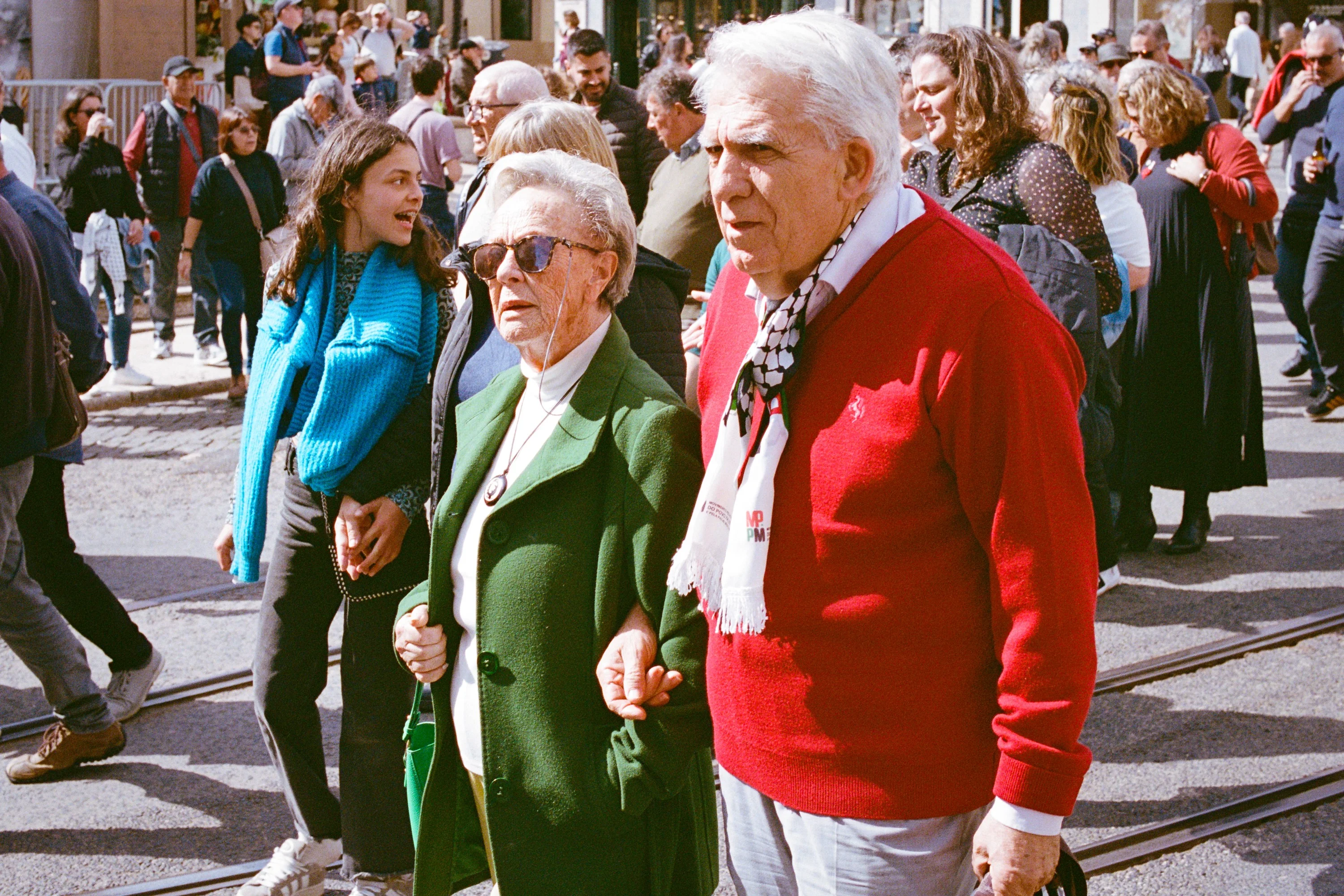 A man in a red jumper and a woman in green at a march