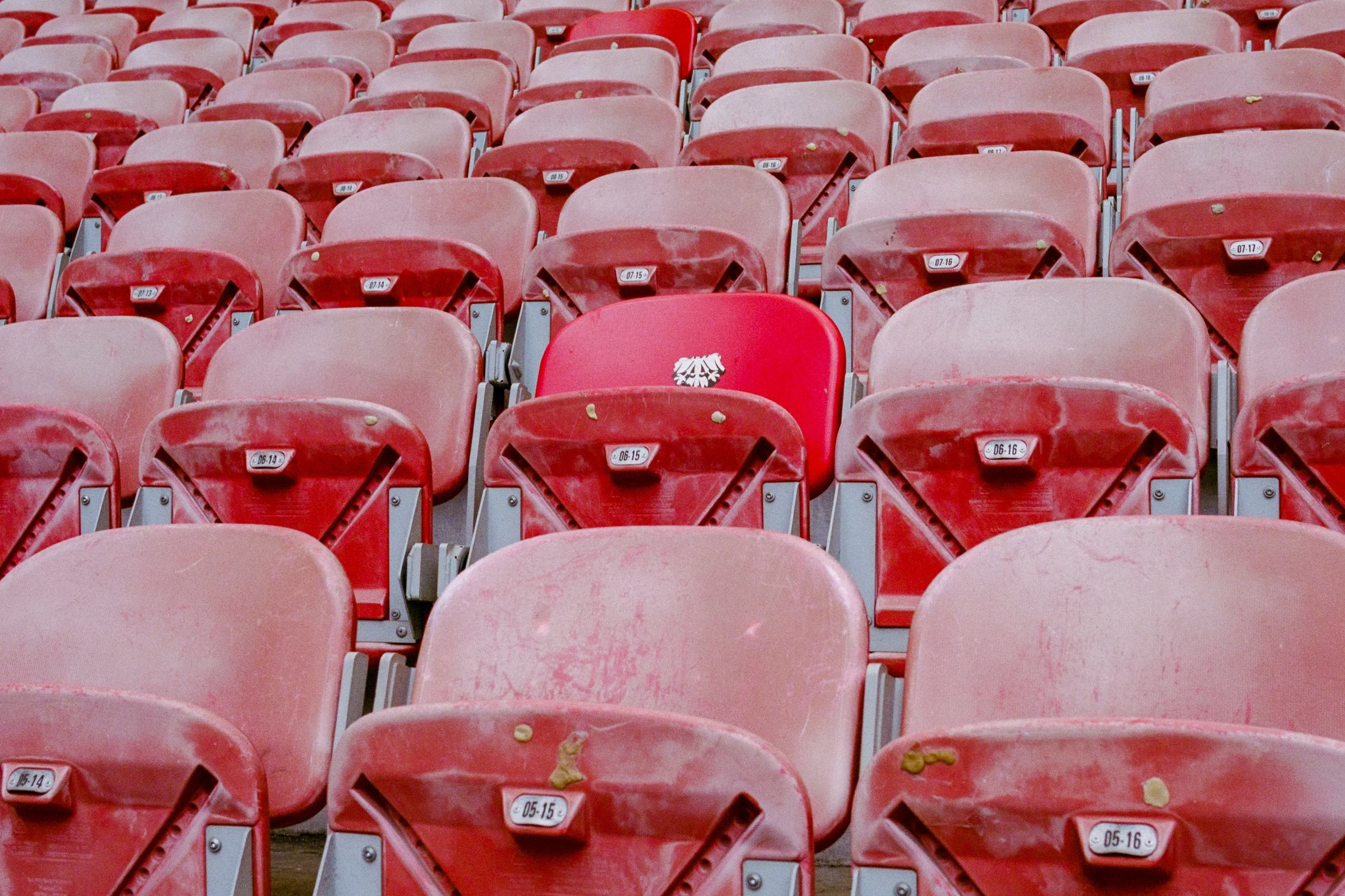 Rows of faded red stadium seats