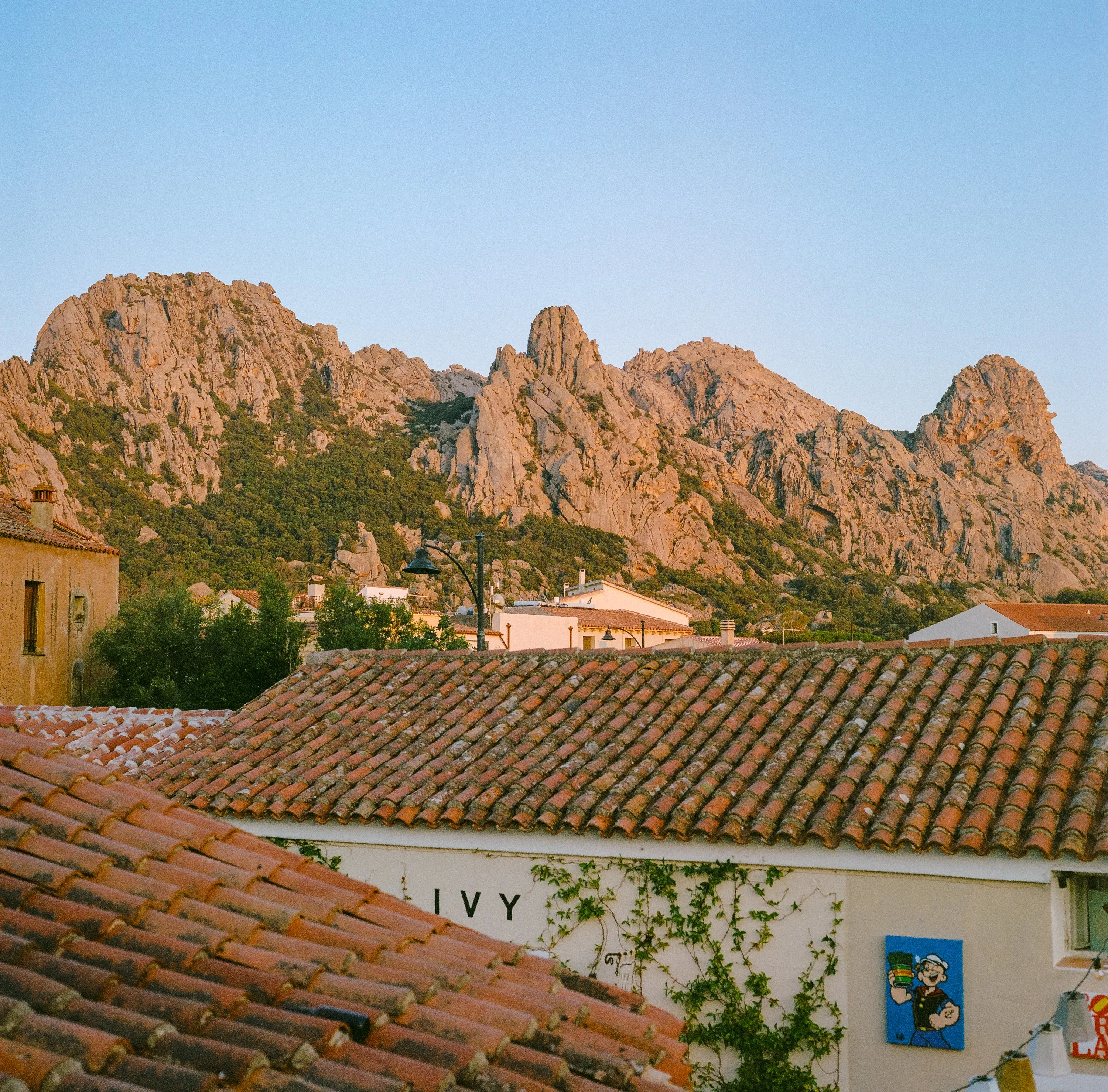 Tiled rooftops below red granite peaks