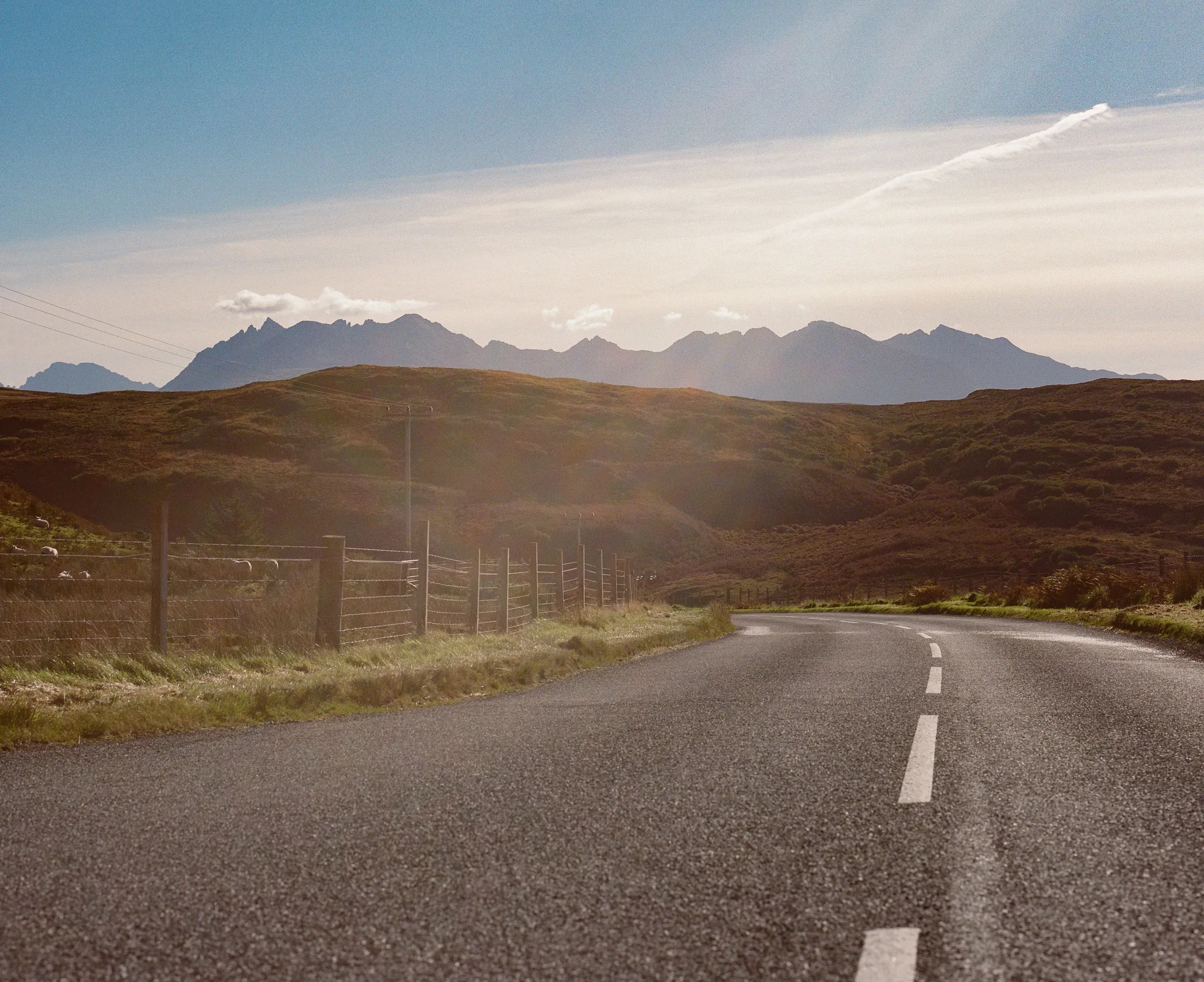 An empty road leading towards distant mountains