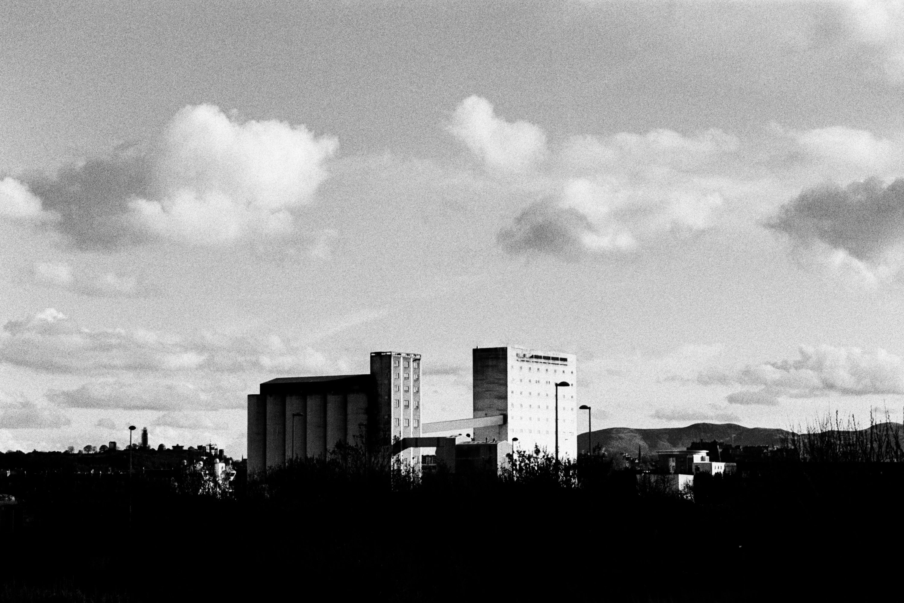 Black and white: an industrial skyline under clouds