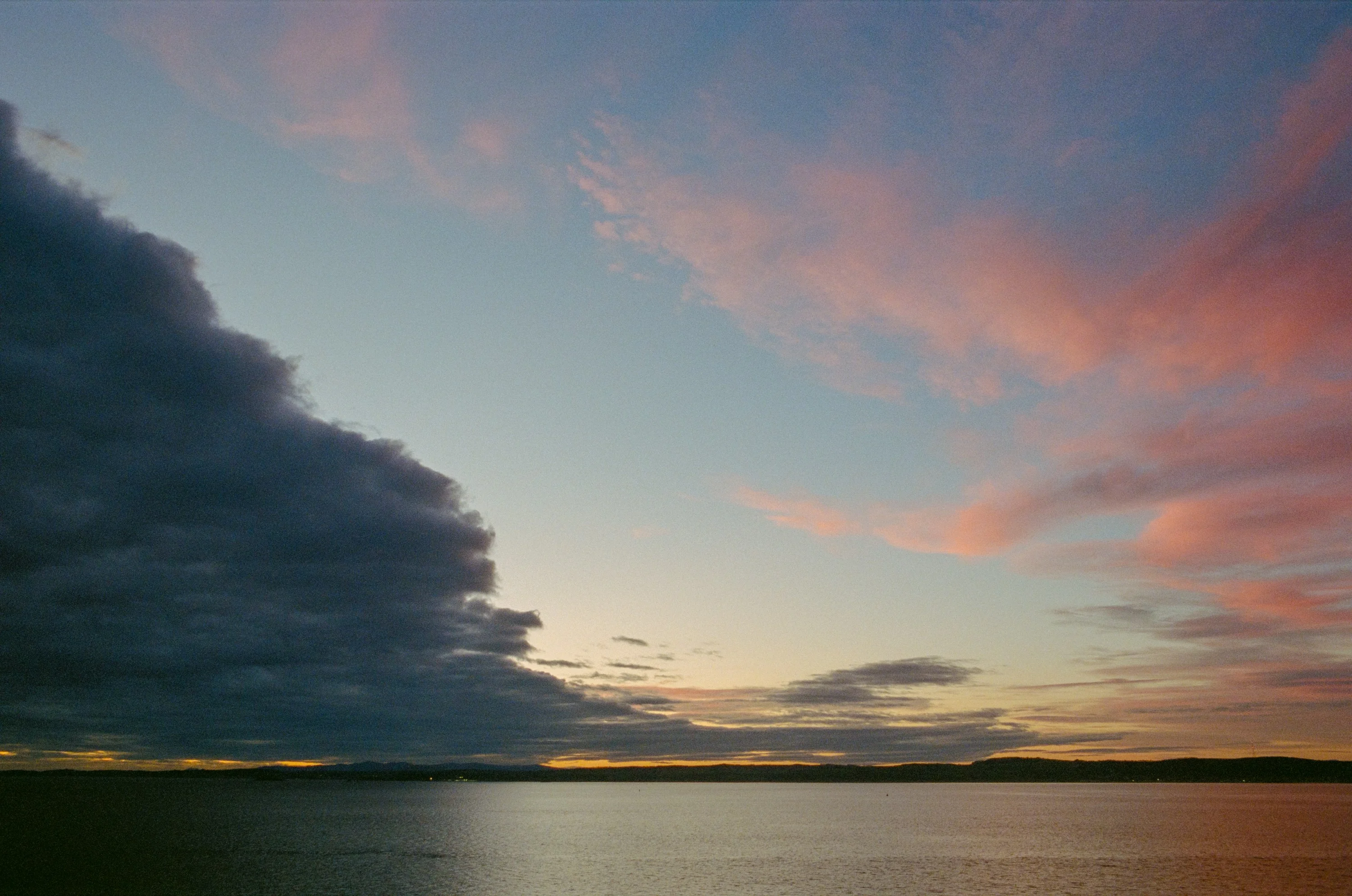 A dark storm cloud and pink sky over the Forth