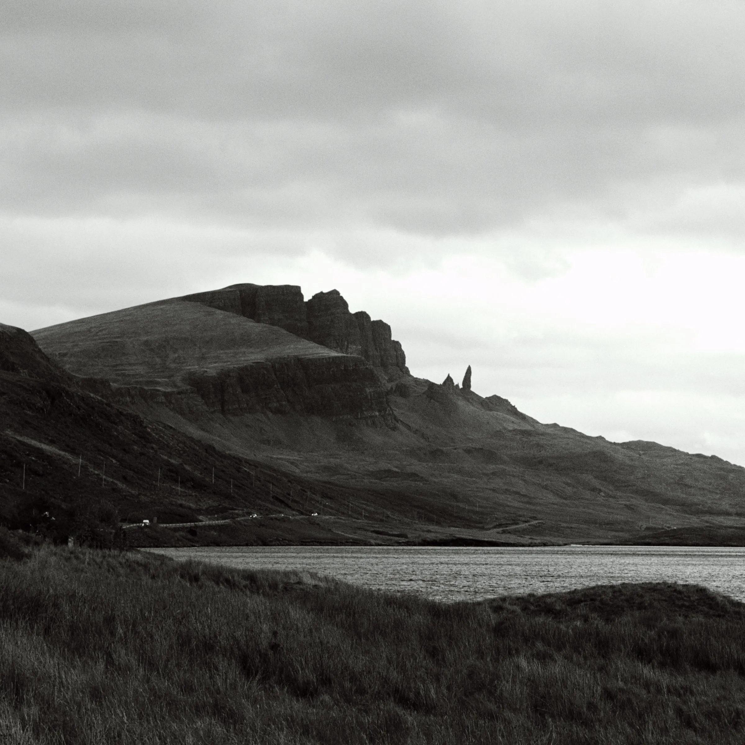 Black and white view of the Storr ridge above a loch