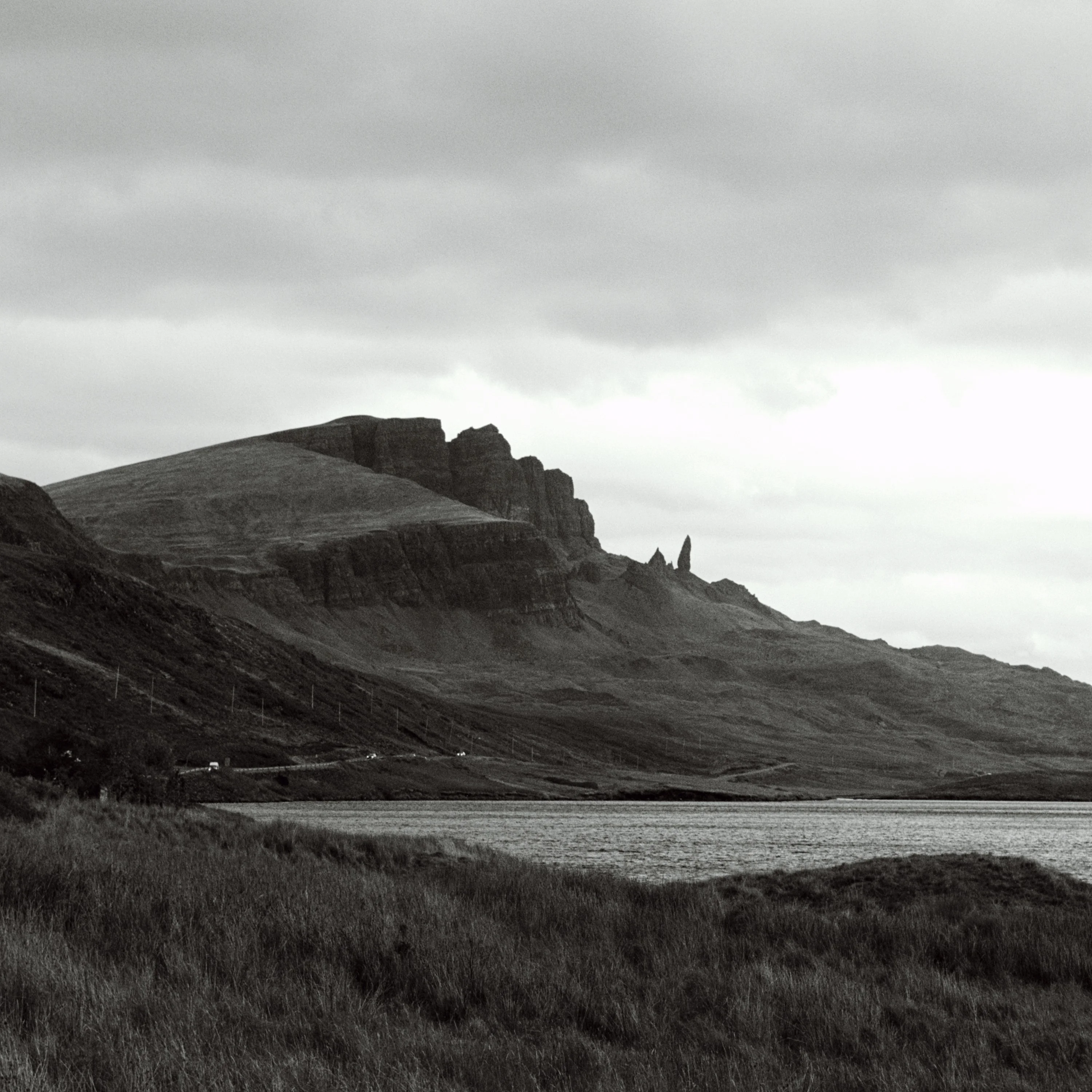 Black and white view of the Storr ridge above a loch
