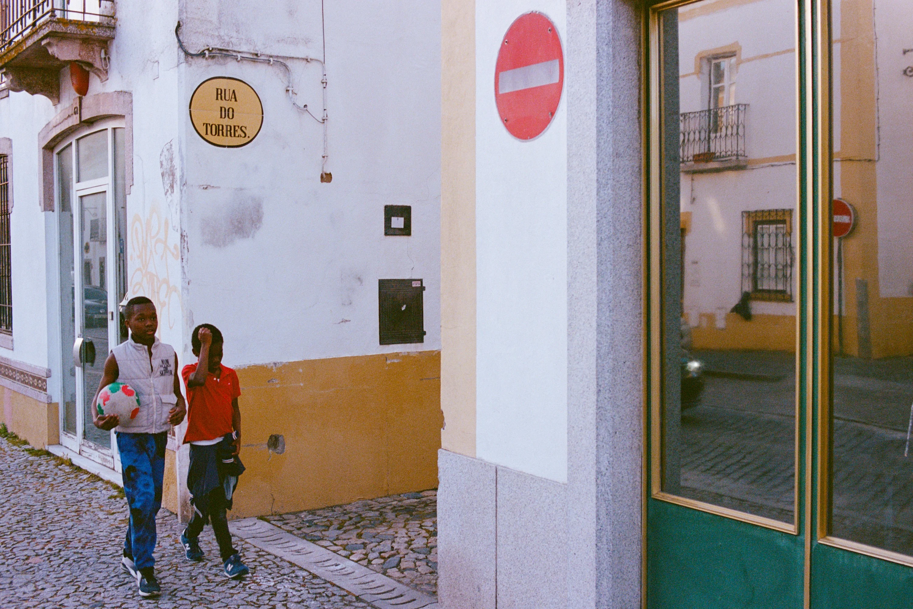 Two boys walking round a street corner