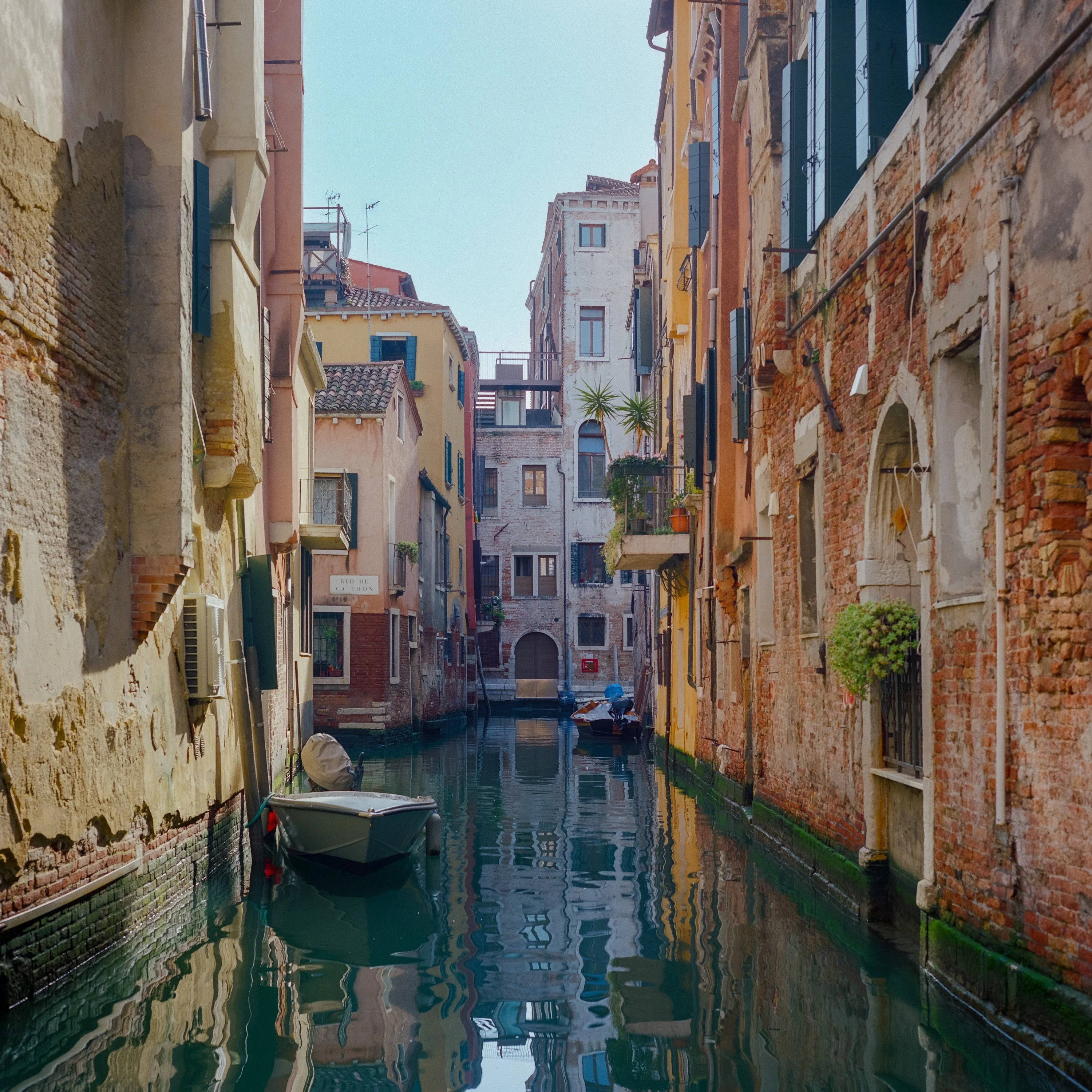 A narrow backwater canal between brick houses