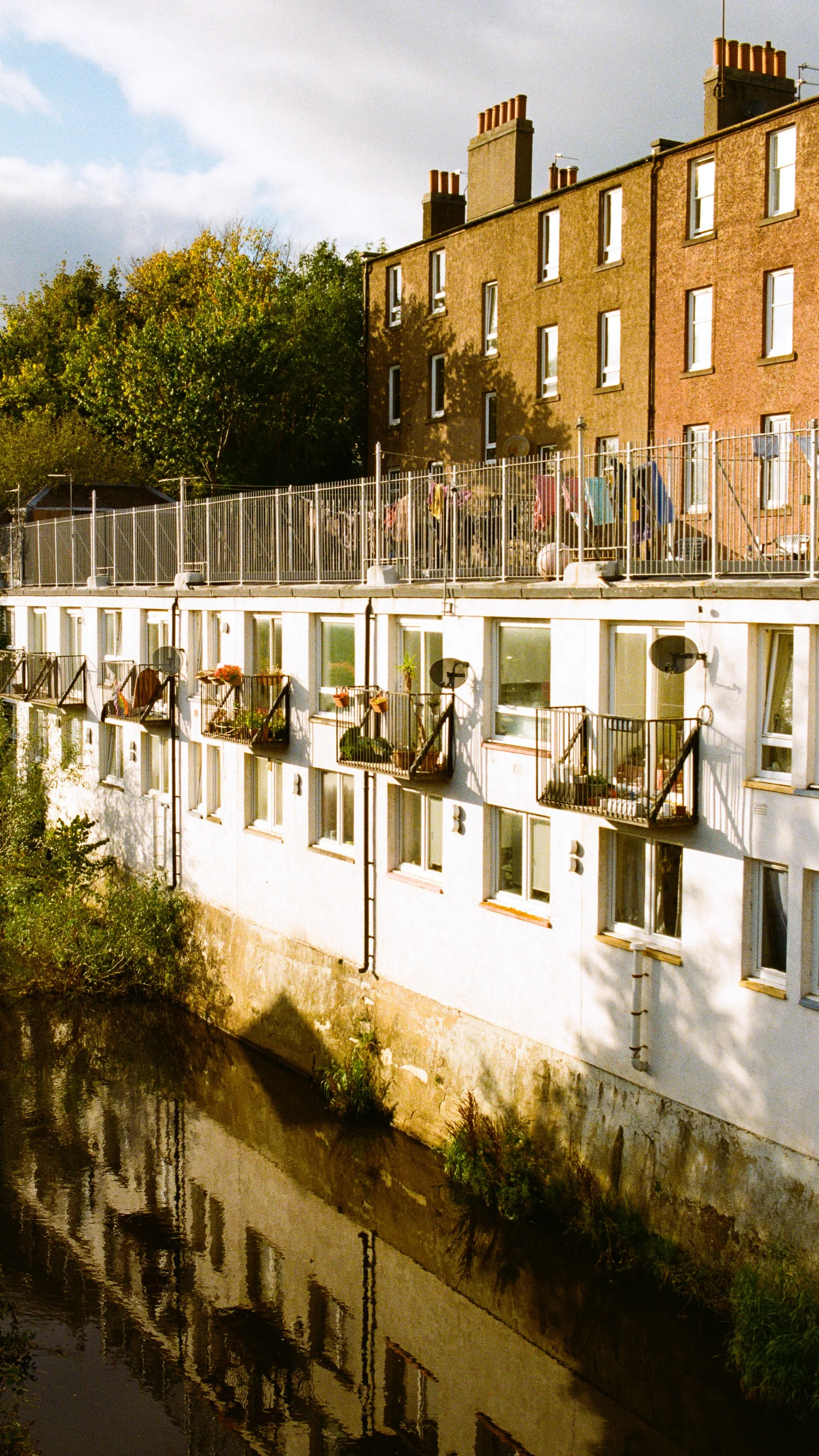 Flats with balconies above the Water of Leith, a tenement behind
